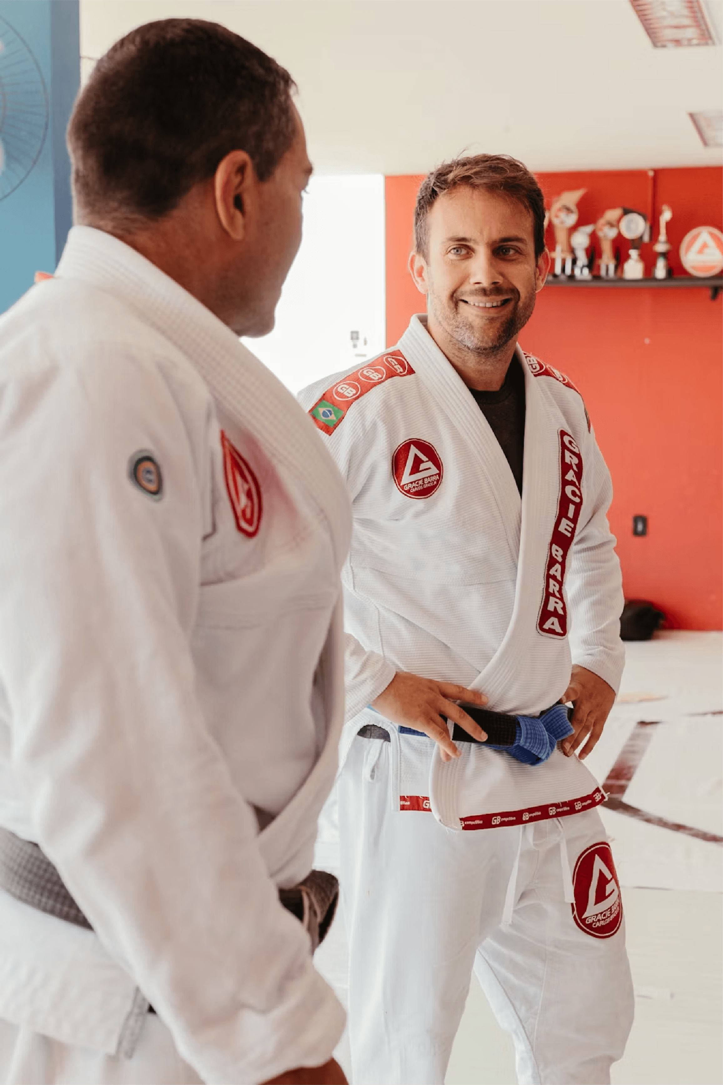 Two Brazilian jiu-jitsu practitioners talking together in the academy